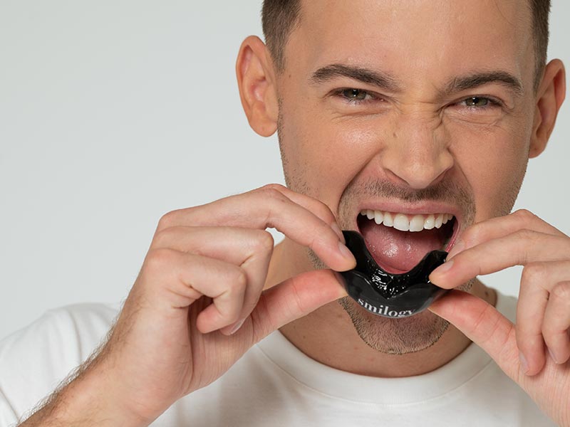 Man putting on a mouthguard