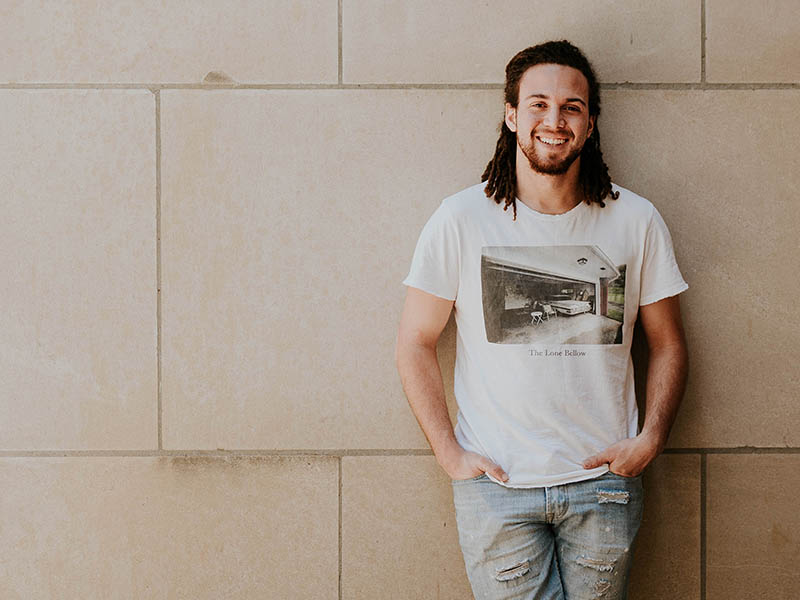 Man leaning against concrete wall