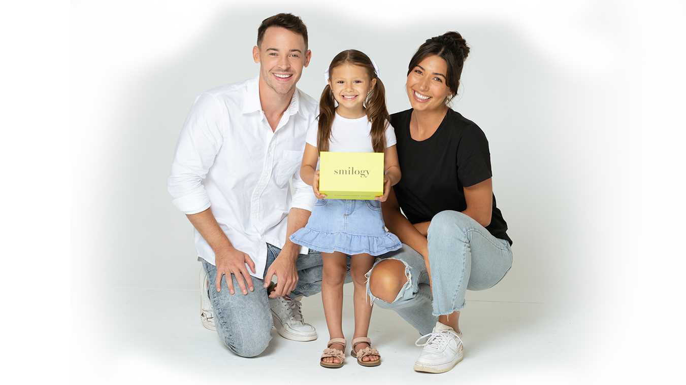 Young couple with daughter holding smilogy box