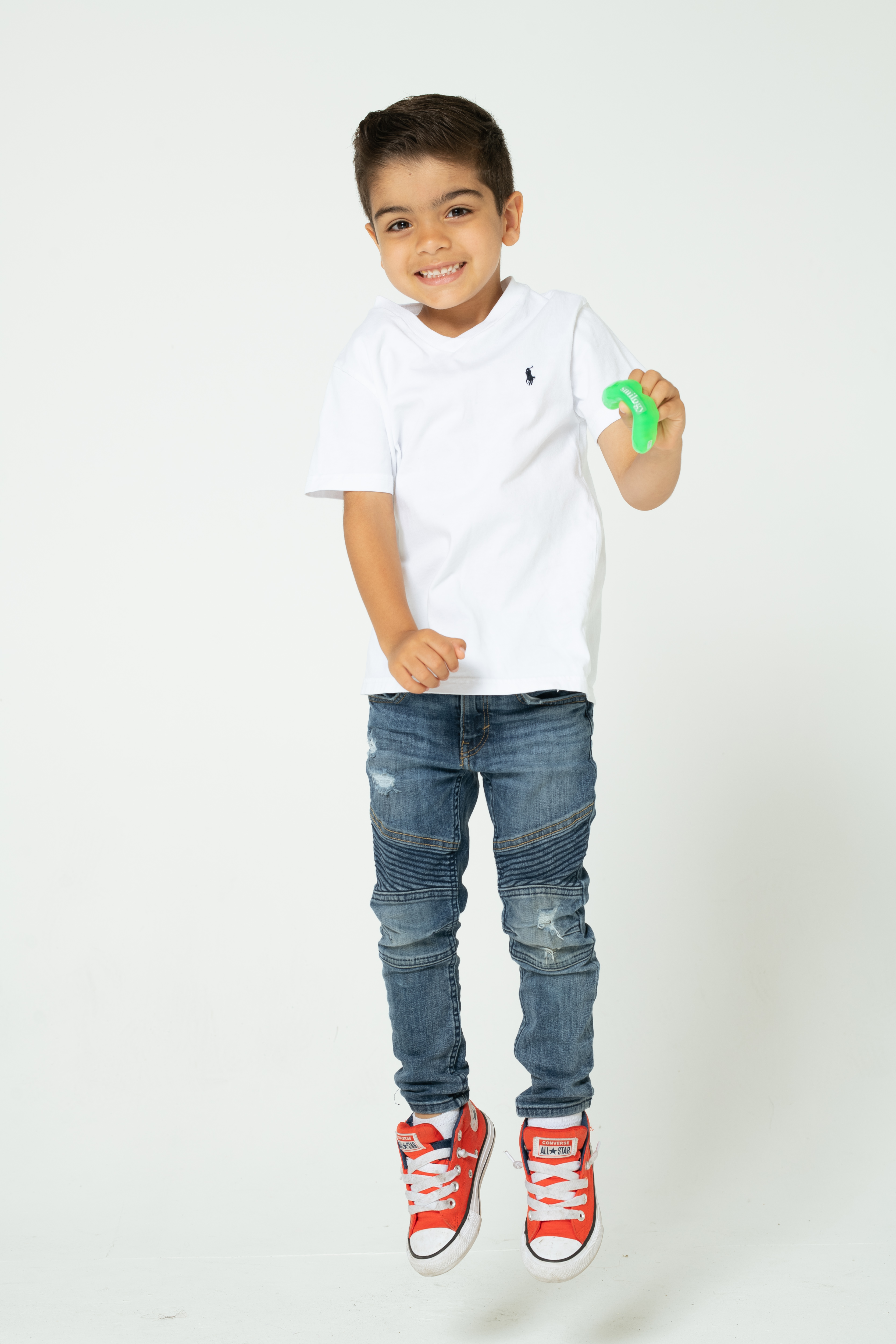 Young boy holding mouthguard and jumping