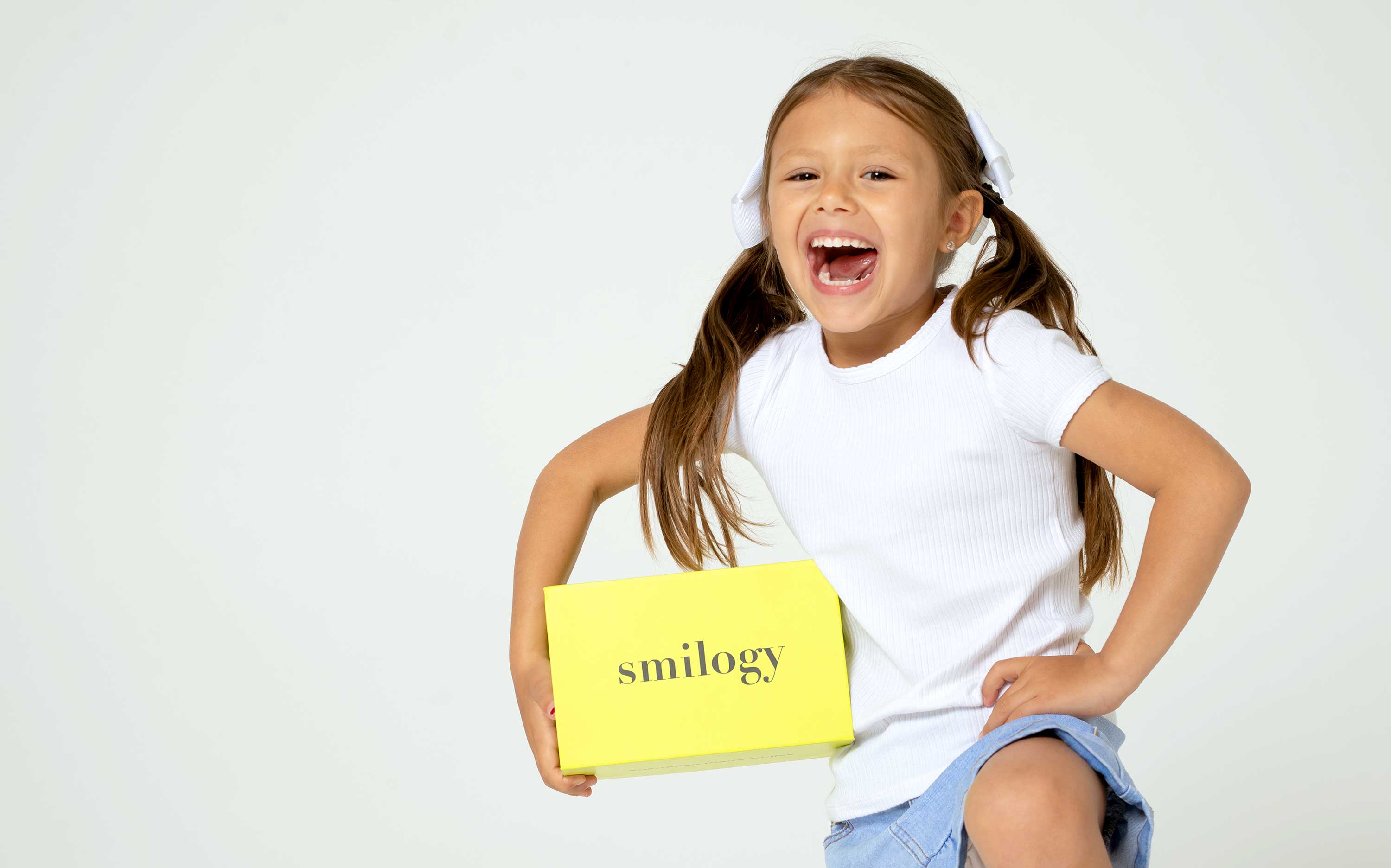 Young girl holding a smilogy box with a big smile