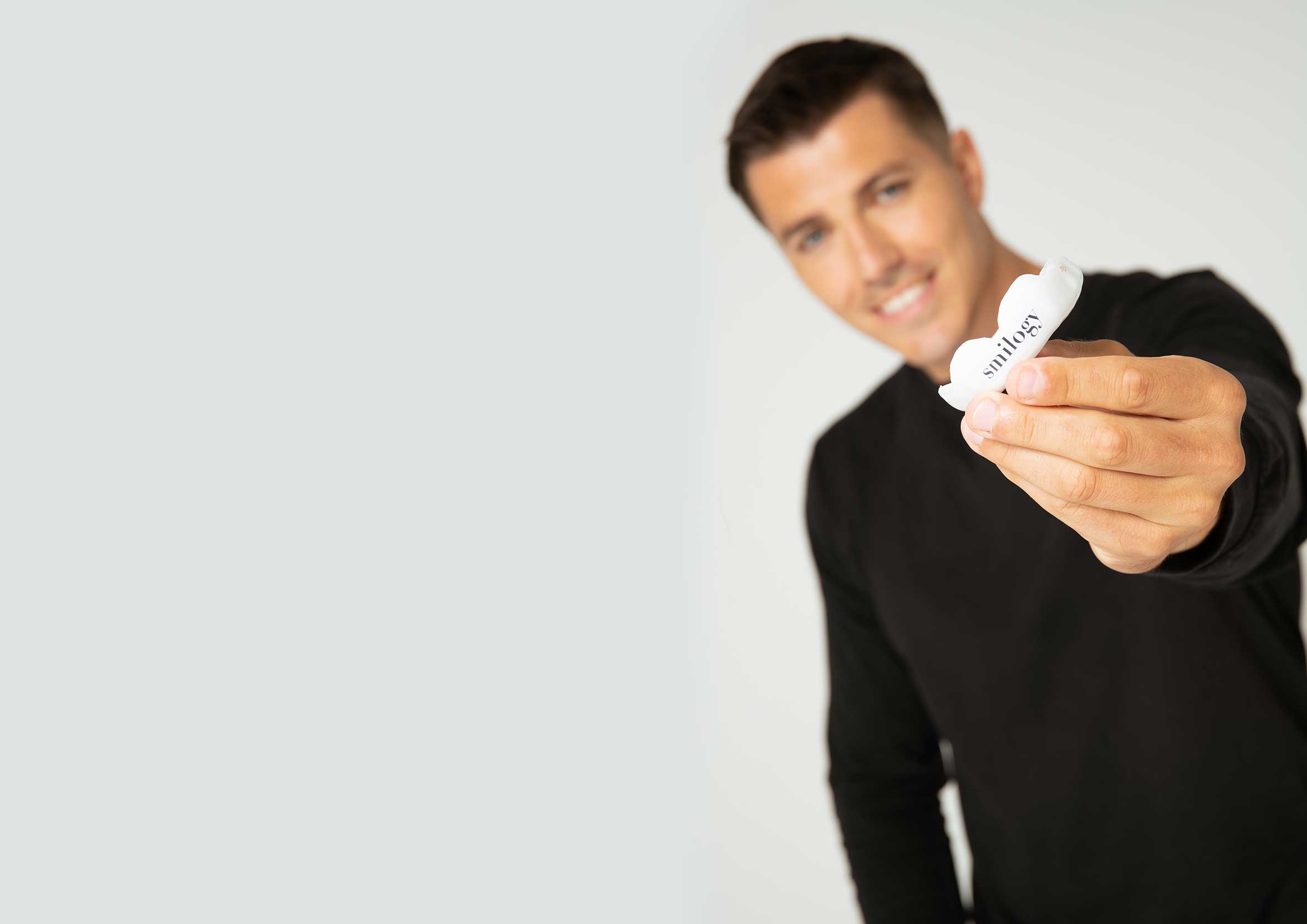 Blurred man holding out a white mouthguard