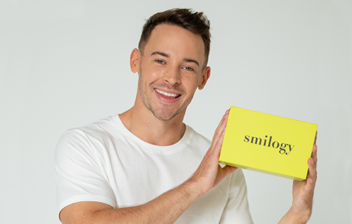 Man smiling and holding a smilogy box